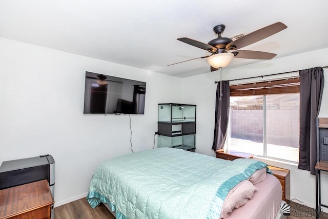 bedroom with a ceiling fan, baseboards, visible vents, and wood finished floors