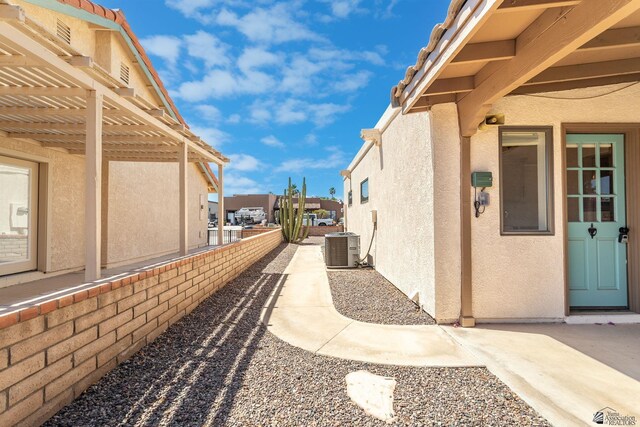 12500 E Del Rico, Yuma, AZ 85367 - view of side of property with central AC unit, stucco siding, and a pergola
