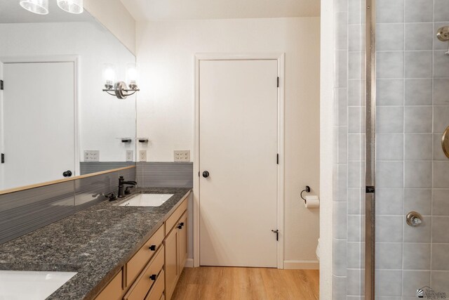 12500 E Del Rico, Yuma, AZ 85367 - full bath with double vanity, tasteful backsplash, a tile shower, wood finished floors, and a sink