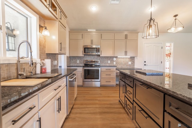 12500 E Del Rico, Yuma, AZ 85367 - kitchen with appliances with stainless steel finishes, hanging light fixtures, tasteful backsplash, a sink, and light wood-style floors