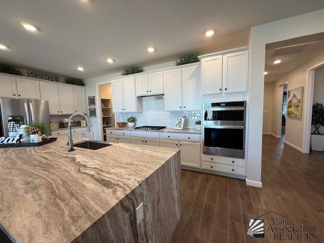 12351 S Drucilla Ln, Yuma, AZ 85367 - kitchen featuring appliances with stainless steel finishes, white cabinets, dark wood-style flooring, light stone counters, and recessed lighting