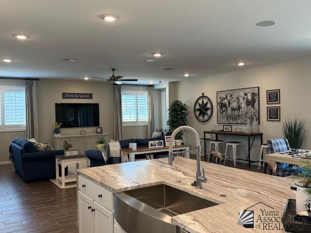 12351 S Drucilla Ln, Yuma, AZ 85367 - kitchen featuring light stone counters, open floor plan, white cabinets, dark wood-type flooring, and recessed lighting
