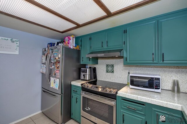 543 E 25th St, Yuma, AZ 85365 - kitchen with stainless steel appliances, under cabinet range hood, and light tile patterned flooring