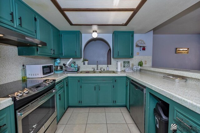 543 E 25th St, Yuma, AZ 85365 - kitchen featuring appliances with stainless steel finishes, under cabinet range hood, light countertops, and light tile patterned flooring