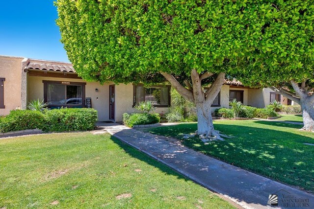 543 E 25th St, Yuma, AZ 85365 - view of front of home featuring stucco siding, a front yard, and a tiled roof