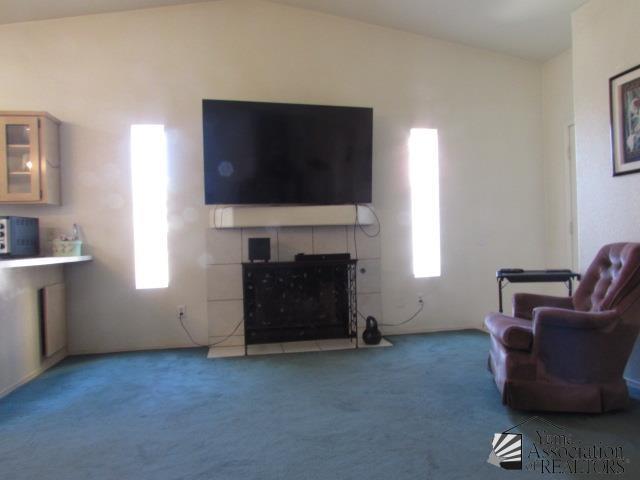 10646 S Via Salida, Yuma, AZ 85367 - living area with carpet floors, a tile fireplace, and vaulted ceiling