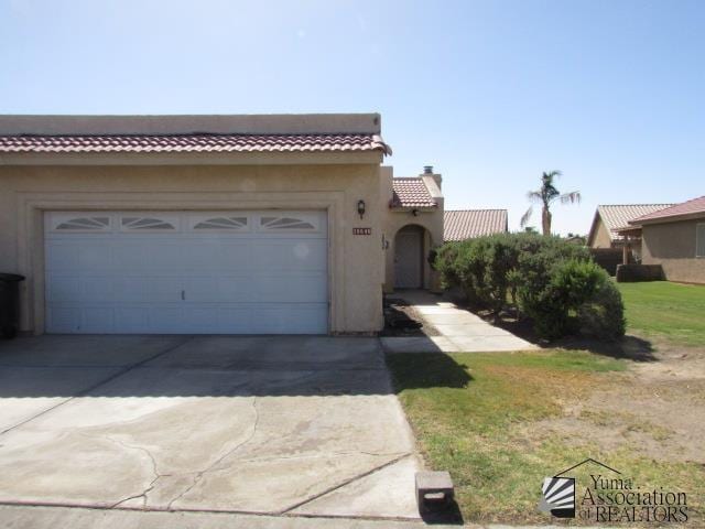 10646 S Via Salida, Yuma, AZ 85367 - view of front of home with driveway, a garage, a tile roof, and a chimney