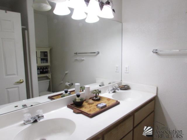 10646 S Via Salida, Yuma, AZ 85367 - full bathroom with toilet, double vanity, and a chandelier