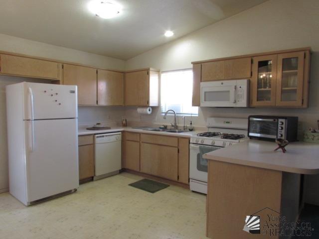10646 S Via Salida, Yuma, AZ 85367 - kitchen featuring white appliances, vaulted ceiling, a sink, light flooring, and light countertops