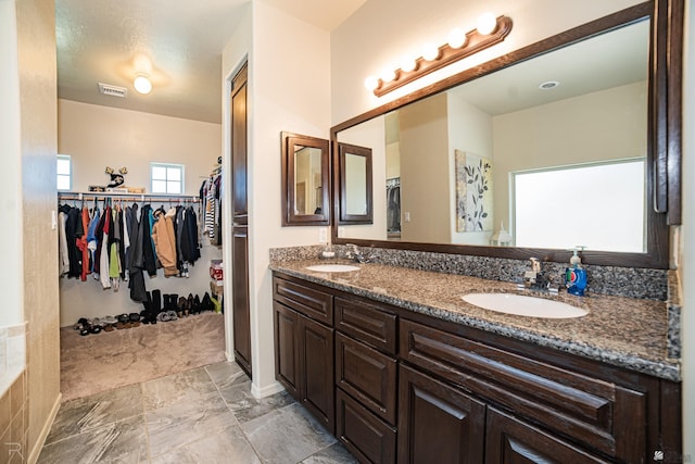 4387 W 24th Pl, Yuma, AZ 85364 - bathroom featuring double vanity, a spacious closet, and marble finish flooring