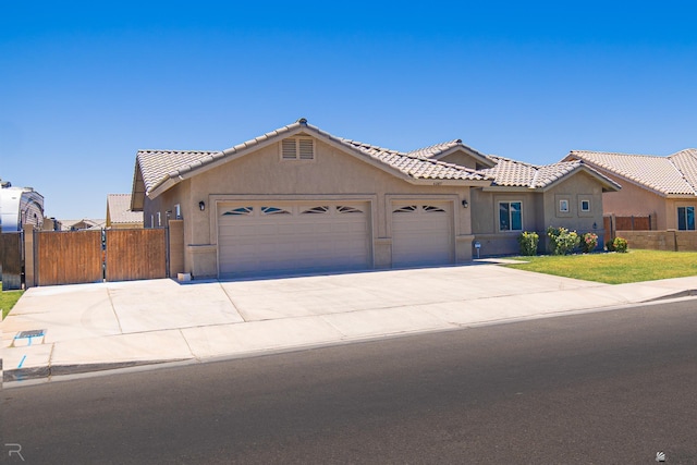 4387 W 24th Pl, Yuma, AZ 85364 - single story home featuring a garage, stucco siding, concrete driveway, a tiled roof, and a gate