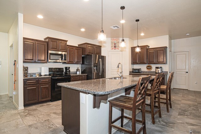 4387 W 24th Pl, Yuma, AZ 85364 - kitchen with stainless steel appliances, a breakfast bar, dark brown cabinetry, and recessed lighting