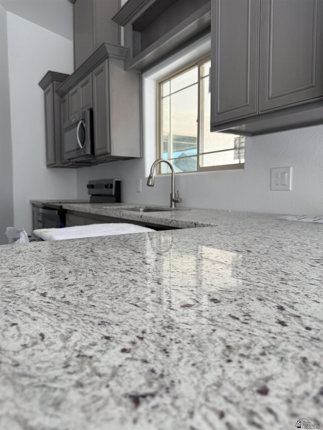 10857 E 45th Pl, Yuma, AZ 85367 - kitchen with stainless steel microwave, electric range, gray cabinetry, and light stone countertops