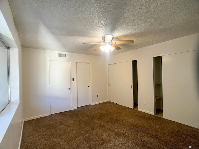 1700 S Crowder Ave, Yuma, AZ 85364 - unfurnished bedroom with two closets, carpet flooring, ceiling fan, and a textured ceiling