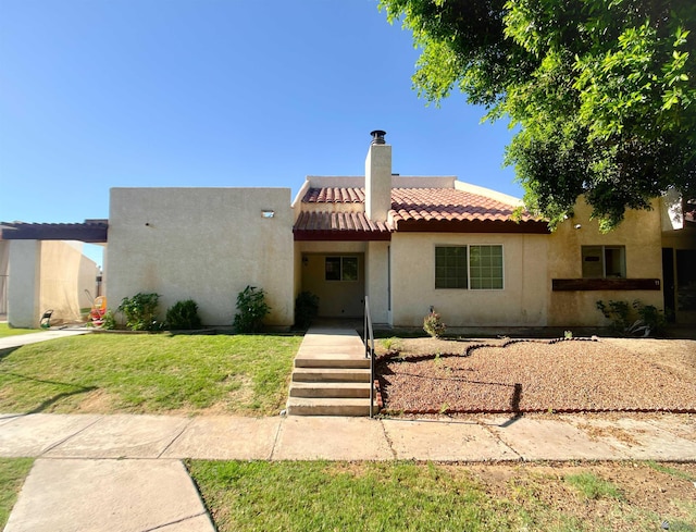 1700 S Crowder Ave, Yuma, AZ 85364 - view of front facade featuring a tiled roof, a chimney, stucco siding, and a front lawn