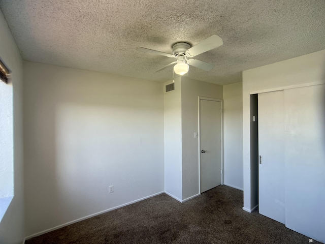 1700 S Crowder Ave, Yuma, AZ 85364 - unfurnished bedroom with dark carpet, a closet, ceiling fan, and a textured ceiling