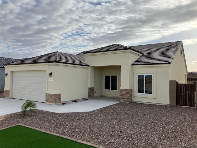 3427 S Akers Way, Yuma, AZ 85365 - back of property featuring stone siding, stucco siding, driveway, a garage, and a tile roof