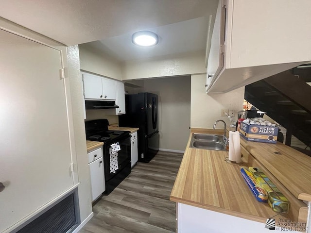 1233 W 20th Pl, Yuma, AZ 85364 - kitchen with dark wood-style flooring, a sink, black appliances, under cabinet range hood, and white cabinetry