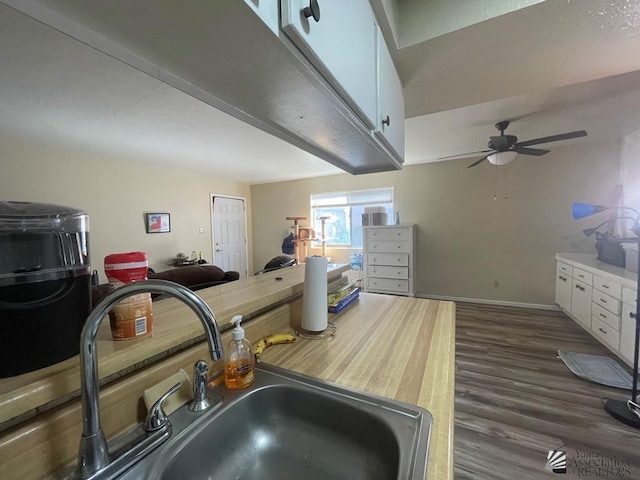 1233 W 20th Pl, Yuma, AZ 85364 - kitchen with ceiling fan, dark wood finished floors, a sink, baseboards, and white cabinets