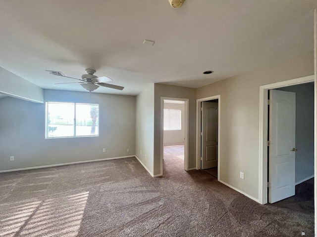 carpeted empty room with plenty of natural light and ceiling fan