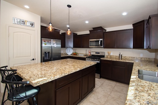 11681 E 33rd St, Yuma, AZ 85367 - kitchen with appliances with stainless steel finishes, light stone countertops, a sink, dark brown cabinets, and a center island