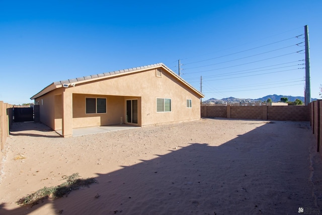 11681 E 33rd St, Yuma, AZ 85367 - rear view of property featuring stucco siding, a fenced backyard, a patio area, and a mountain view
