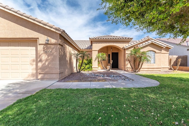 12170 E 33rd Pl, Yuma, AZ 85367 - mediterranean / spanish-style house with a front yard, stucco siding, a garage, a tile roof, and concrete driveway