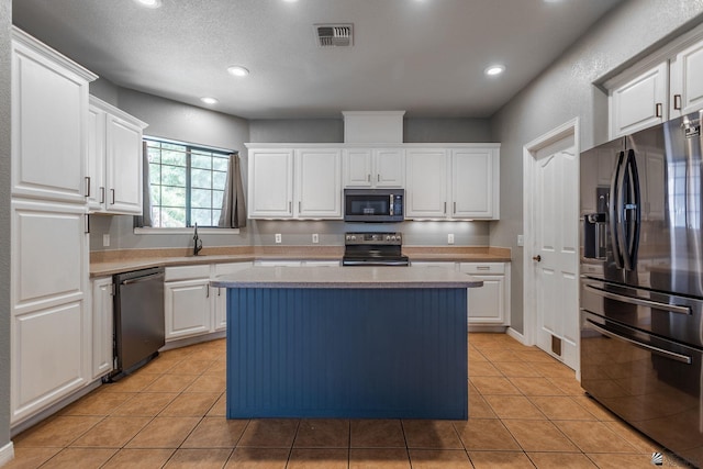 12170 E 33rd Pl, Yuma, AZ 85367 - kitchen featuring appliances with stainless steel finishes, white cabinets, light countertops, a kitchen island, and recessed lighting