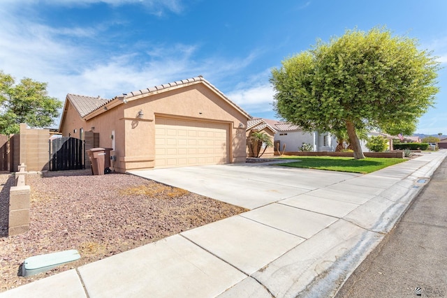 12170 E 33rd Pl, Yuma, AZ 85367 - view of front facade featuring stucco siding, driveway, a garage, a gate, and a tiled roof