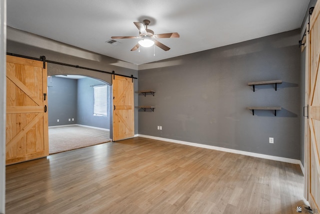 12170 E 33rd Pl, Yuma, AZ 85367 - unfurnished room featuring a barn door, a ceiling fan, baseboards, and light wood-type flooring