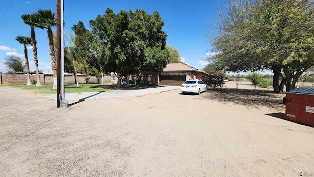 obstructed view of property featuring fence, driveway, and a garage