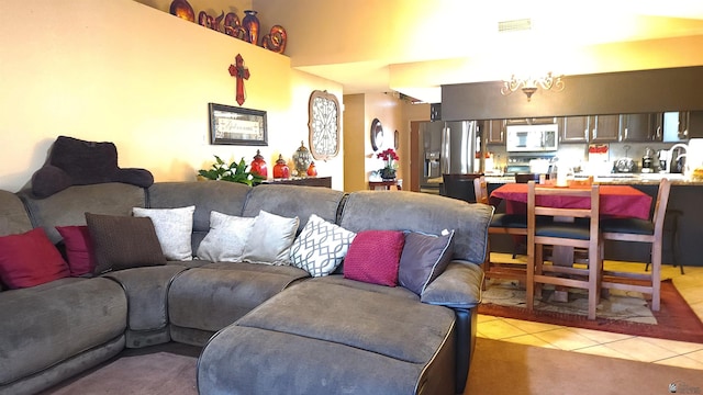 living area with a chandelier, visible vents, and light tile patterned floors