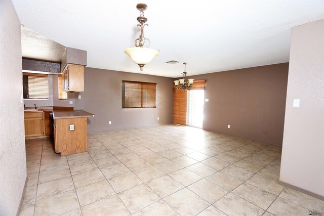 3023 W 26th St, Yuma, AZ 85364 - kitchen with a chandelier, a peninsula, light tile patterned flooring, open floor plan, and hanging light fixtures