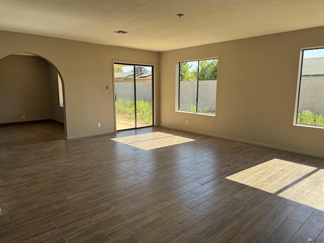 1276 S Pagent Ave, Yuma, AZ 85364 - empty room featuring arched walkways and dark wood finished floors
