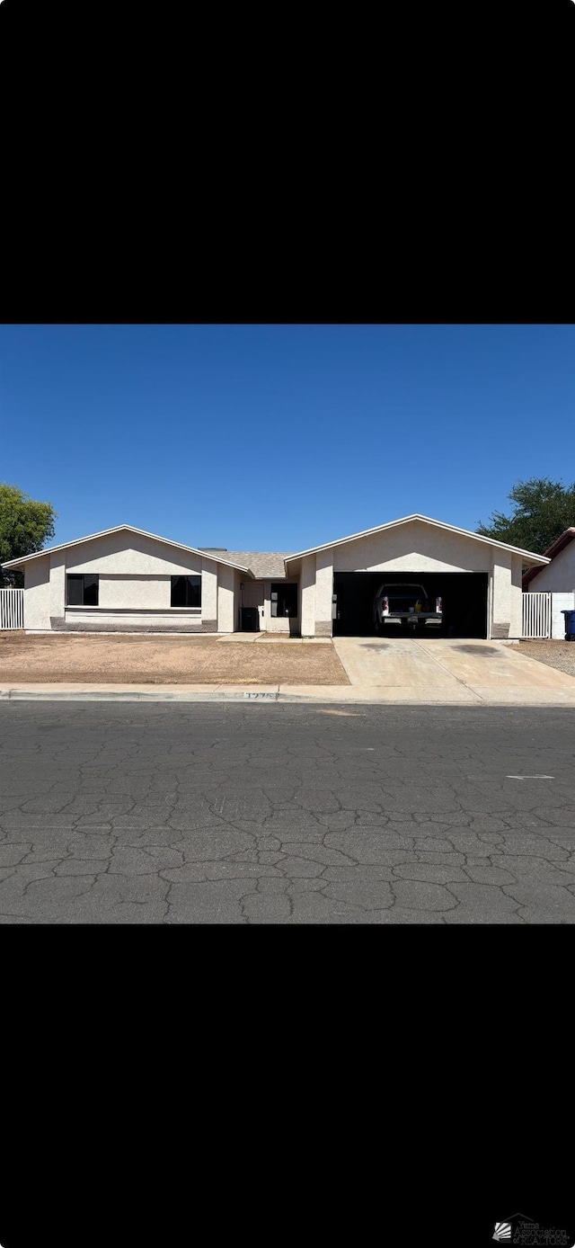 1276 S Pagent Ave, Yuma, AZ 85364 - view of front of property featuring concrete driveway, an attached garage, and stucco siding
