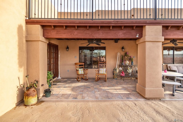 view of patio with a ceiling fan and a balcony