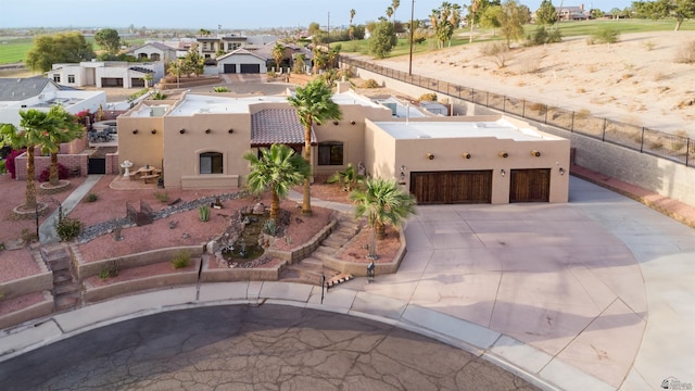 view of front of house with concrete driveway, a garage, a residential view, and stucco siding