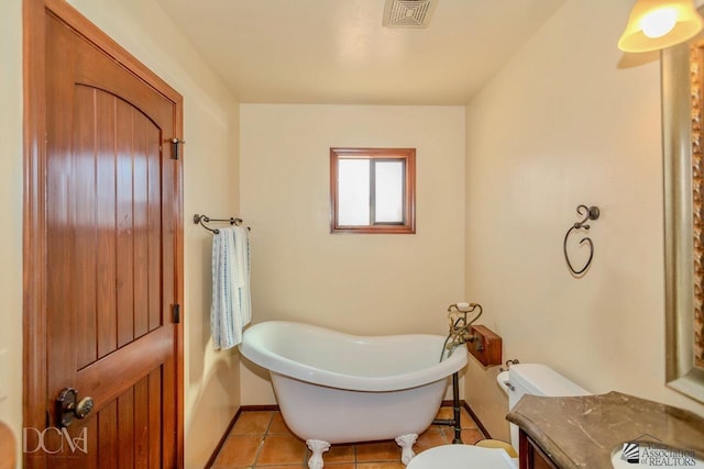 full bath with visible vents, a freestanding tub, toilet, baseboards, and tile patterned floors