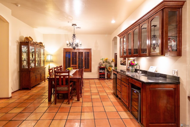 bar with an inviting chandelier, a sink, wine cooler, arched walkways, and decorative light fixtures