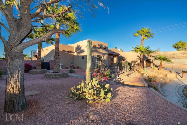 exterior space featuring stucco siding and fence