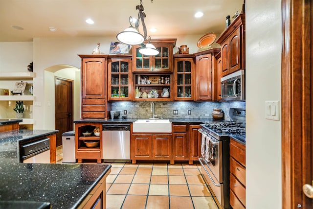 kitchen with backsplash, appliances with stainless steel finishes, arched walkways, open shelves, and a sink