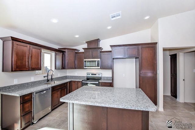 12546 E 51st Pl, Yuma, AZ 85367 - kitchen with appliances with stainless steel finishes, light stone counters, a sink, a kitchen island, and visible vents