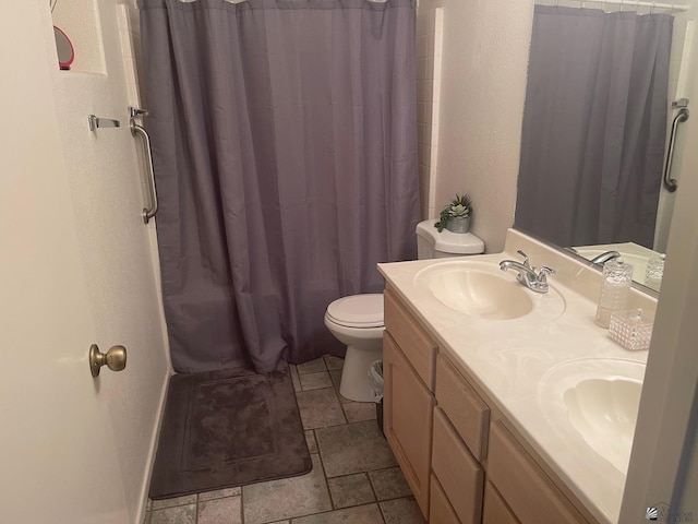 full bath featuring double vanity, toilet, a shower with shower curtain, and a sink