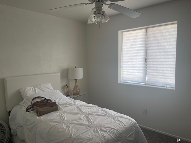 carpeted bedroom featuring baseboards, multiple windows, and ceiling fan