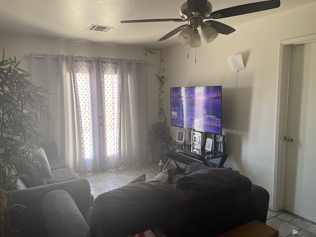 living room with visible vents, a textured ceiling, ceiling fan, and light tile patterned flooring