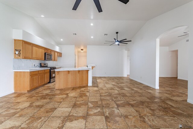 3481 W 27th Ln, Yuma, AZ 85364 - kitchen with stainless steel appliances, a ceiling fan, light countertops, baseboards, and high vaulted ceiling