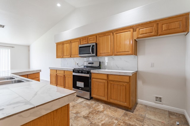 3481 W 27th Ln, Yuma, AZ 85364 - kitchen with stainless steel appliances, vaulted ceiling, tasteful backsplash, and light countertops