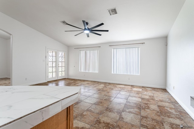 3481 W 27th Ln, Yuma, AZ 85364 - unfurnished living room featuring ceiling fan, baseboards, arched walkways, vaulted ceiling, and light stone finish floors