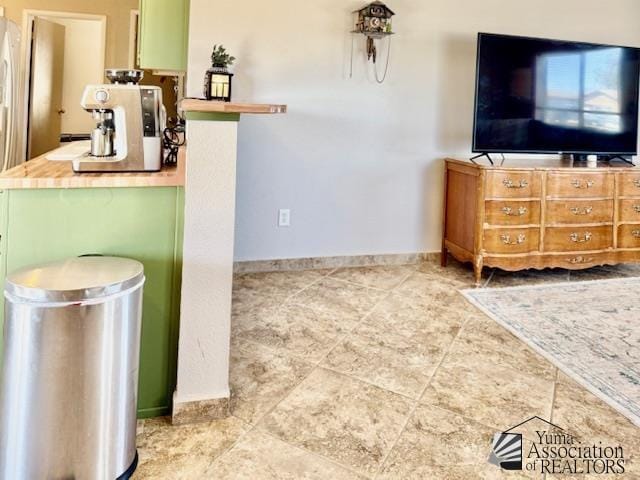 kitchen with tile patterned floors, green cabinets, and baseboards