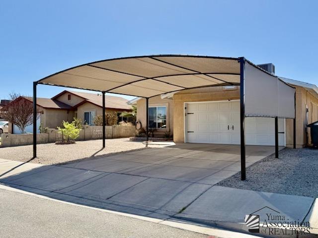 exterior space featuring a garage, central air condition unit, and a carport